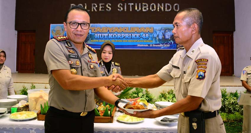 Kapolres Situbondo tampak memberikan potongan tumpeng kepada Pengda Tk I Mujianto sebagai ASN yang memasuki masa pensiun. (imam)