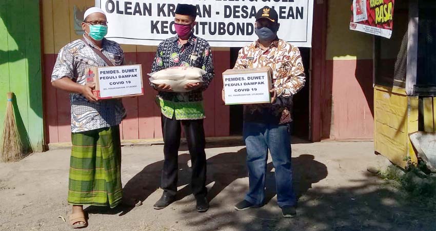 BERI BANTUAN: Kepala Desa Duwet, Kecamatan Panarukan, Bapak Chandra tampak menyerahkan bantuan logistik pada koordinator lumbung pangan Kampung Tangguh Tenggir Barat . (her/im)