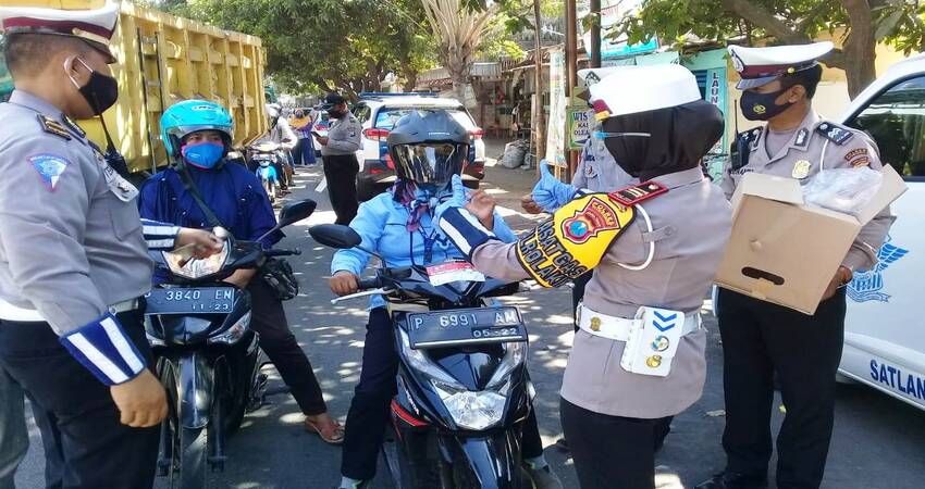 BERIKAN REWARD : Kasat Lantas Polres Situbondo AKP Indah Citra Fitriani SIK saat memberikan helm gratis pada pengendara sepeda motor yang tertib. (im)